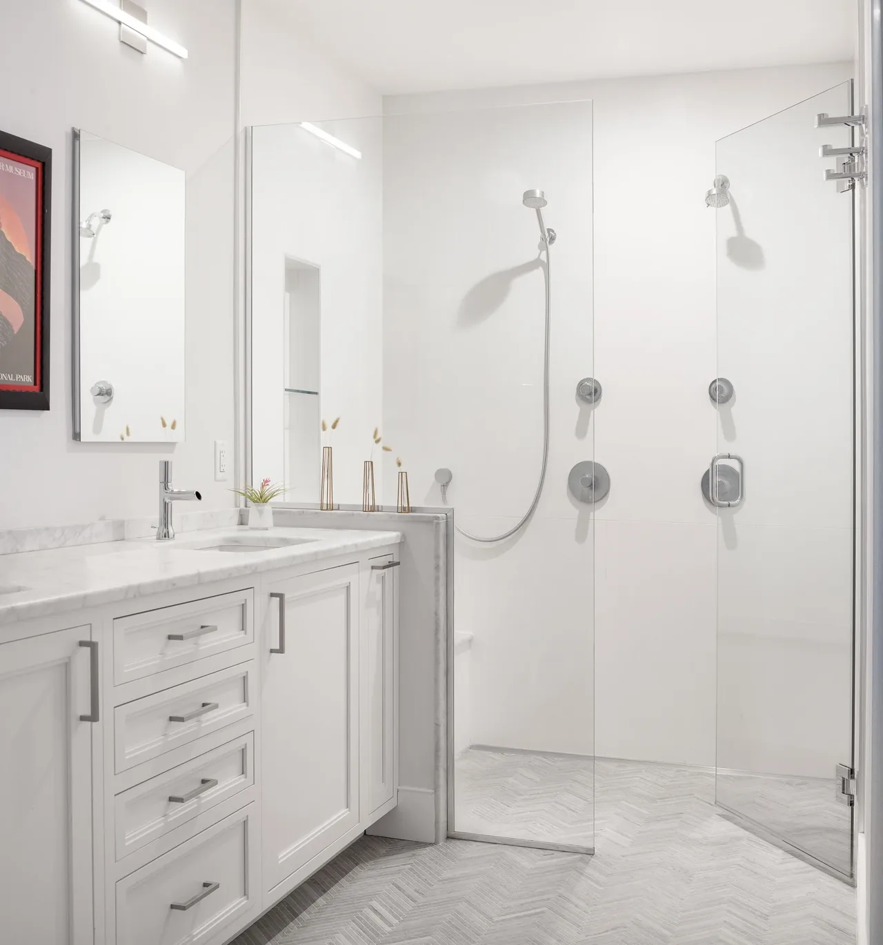 The bathroom features a walk-in glass shower with a white vanity topped with marble countertop.