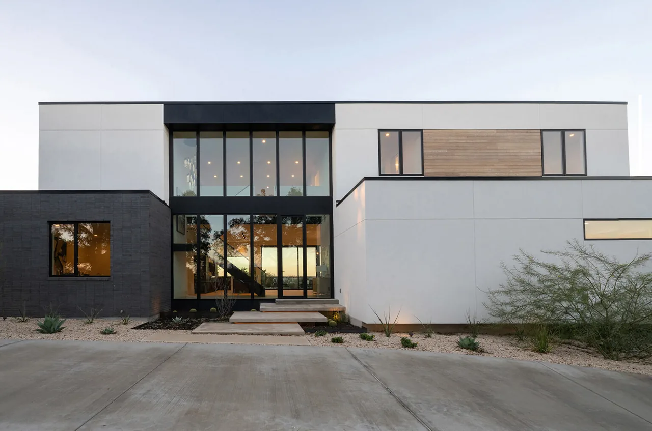 Front exterior of Jade house showing a modern design with floor-to-ceiling glazing and mixed materials.