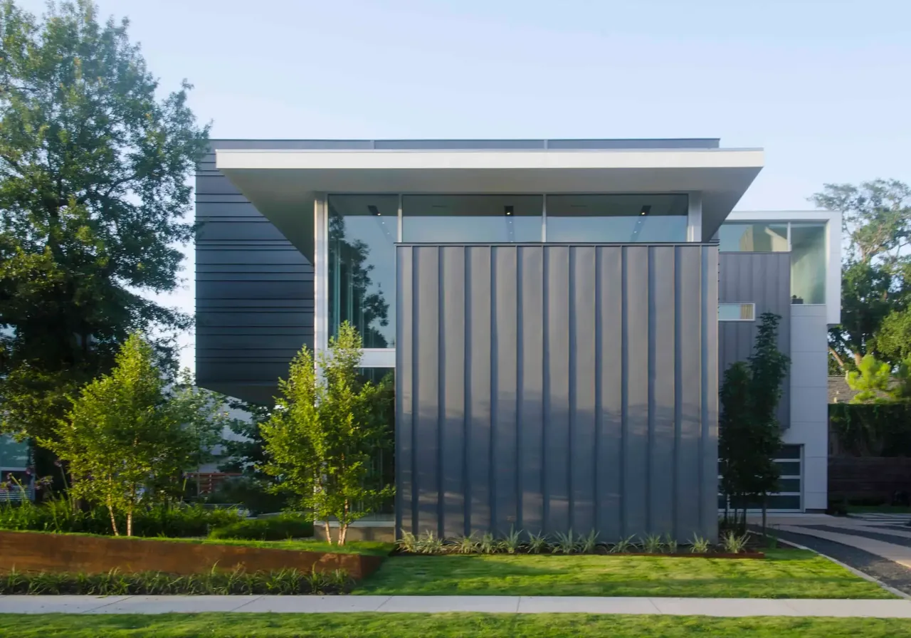 Modern Jade House by Intexure features large glass windows and vertical metal panel siding.