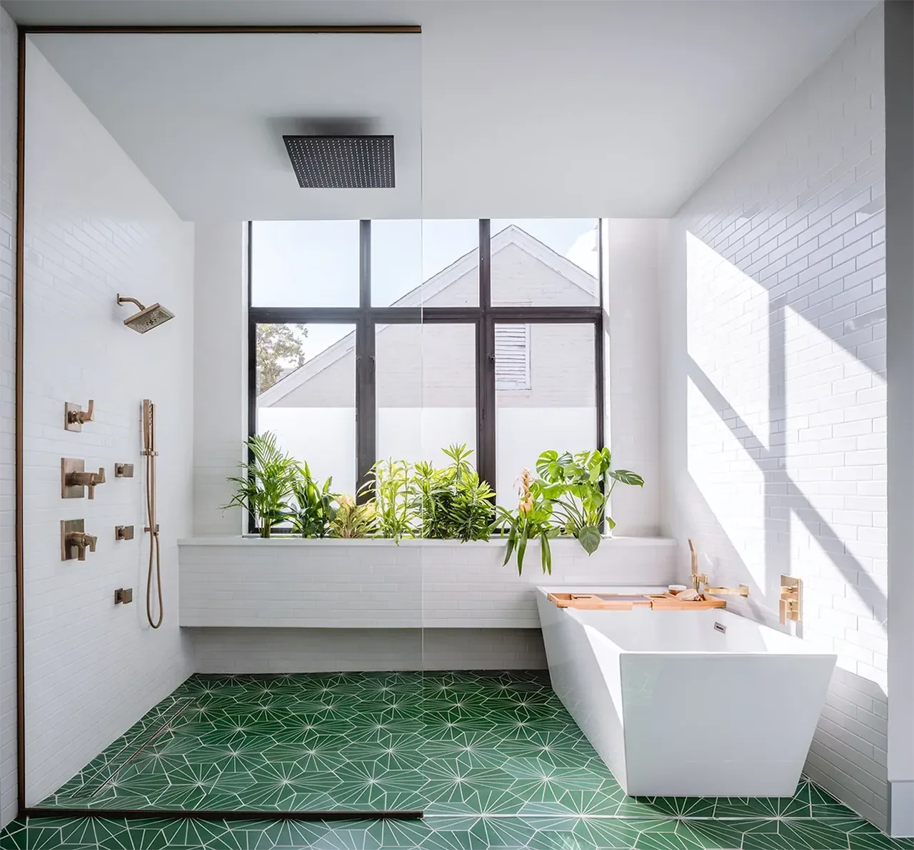 Bathroom in Windemere Residence with a freestanding tub and geometric green tile floor, featuring large black-framed windows and white brick walls.