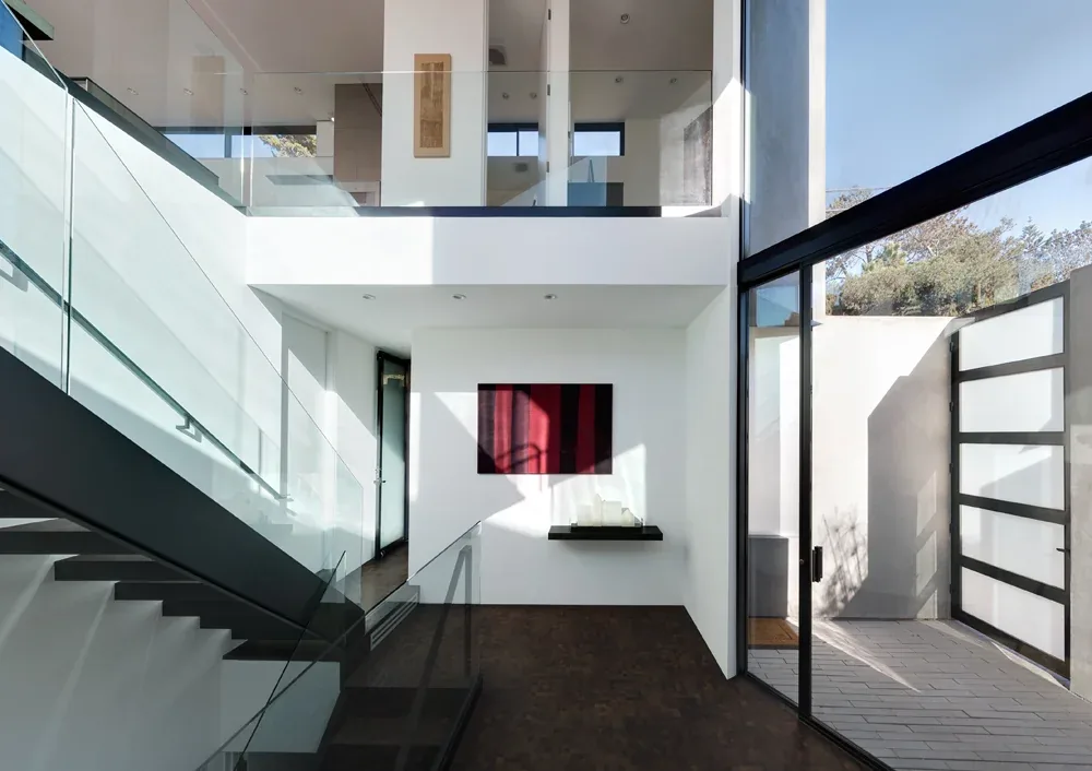 Staircase area with glass railings and black window frames in Neptune House by Batter Kay Associates.
