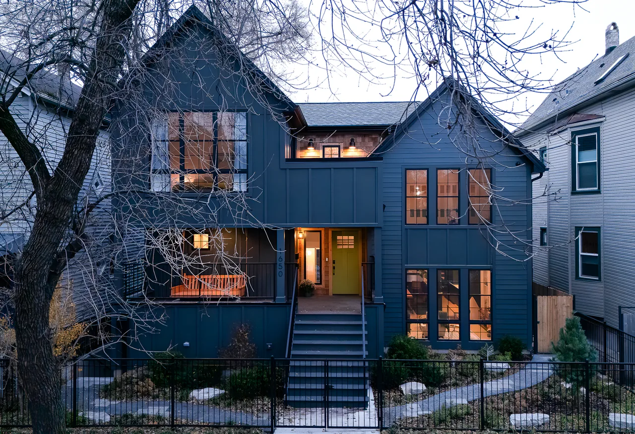 The Mozart House features dark siding and a green front door with multiple stair-access points in an urban setting.