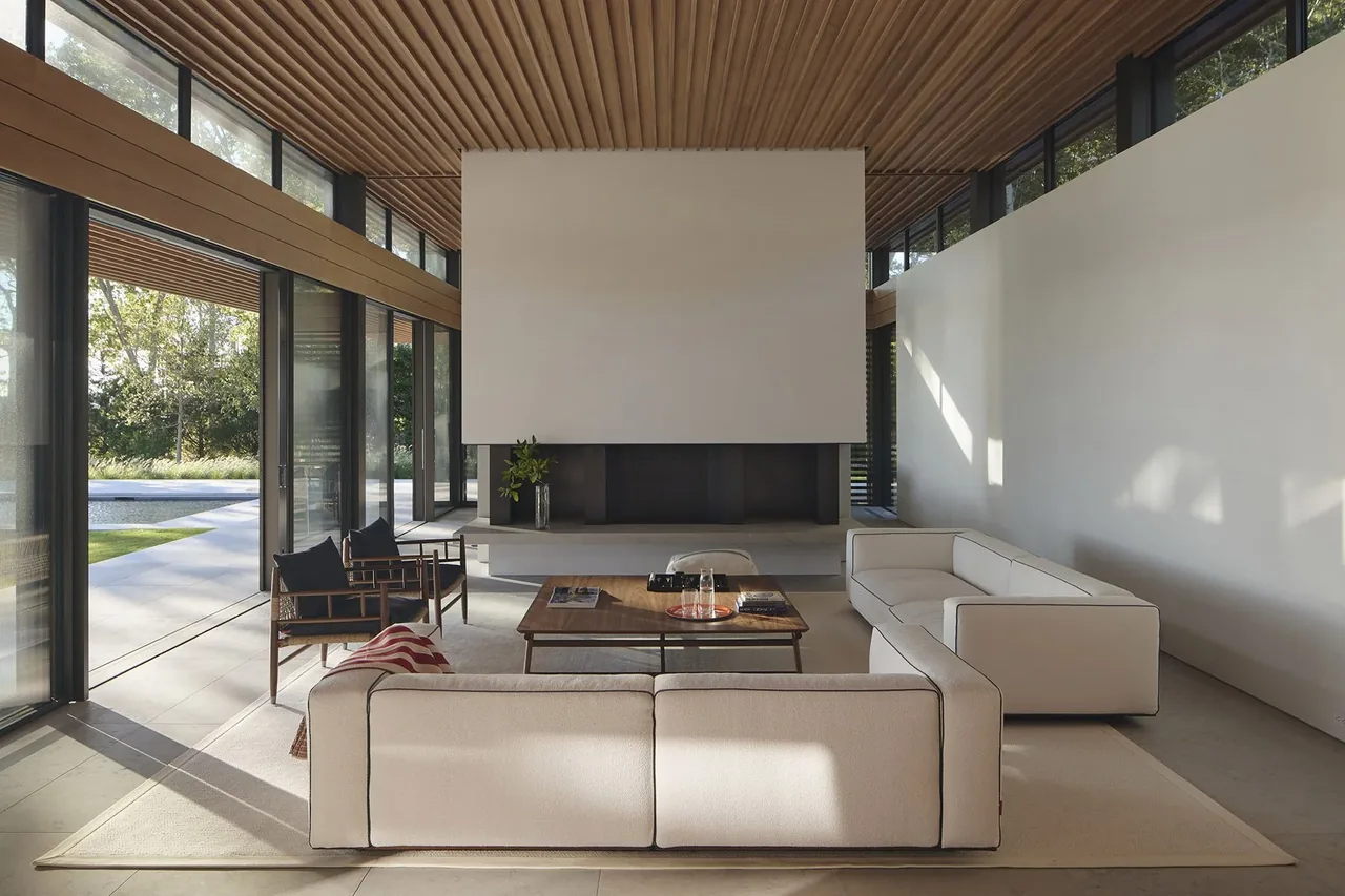 Living room featuring floor-to-ceiling glazing, a large suspended fireplace, and a wood-slat ceiling design.
