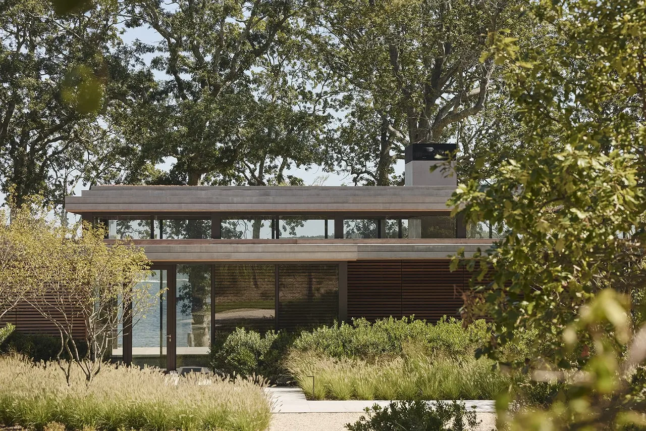 Exterior front elevation of the Forest Edge project featuring horizontal wood slats and extensive greenery.