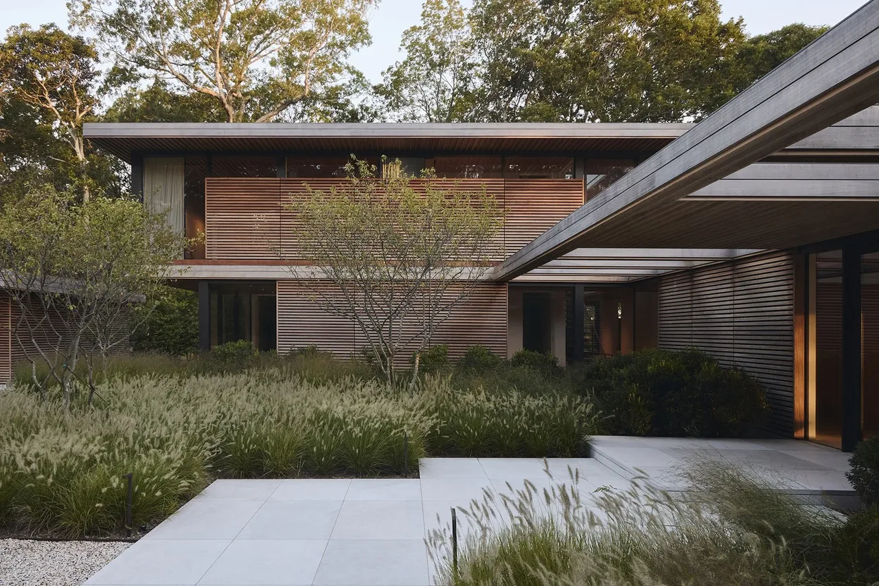 FOREST EDGE features horizontal wood siding and flat roofs with expansive landscaping in the courtyard.