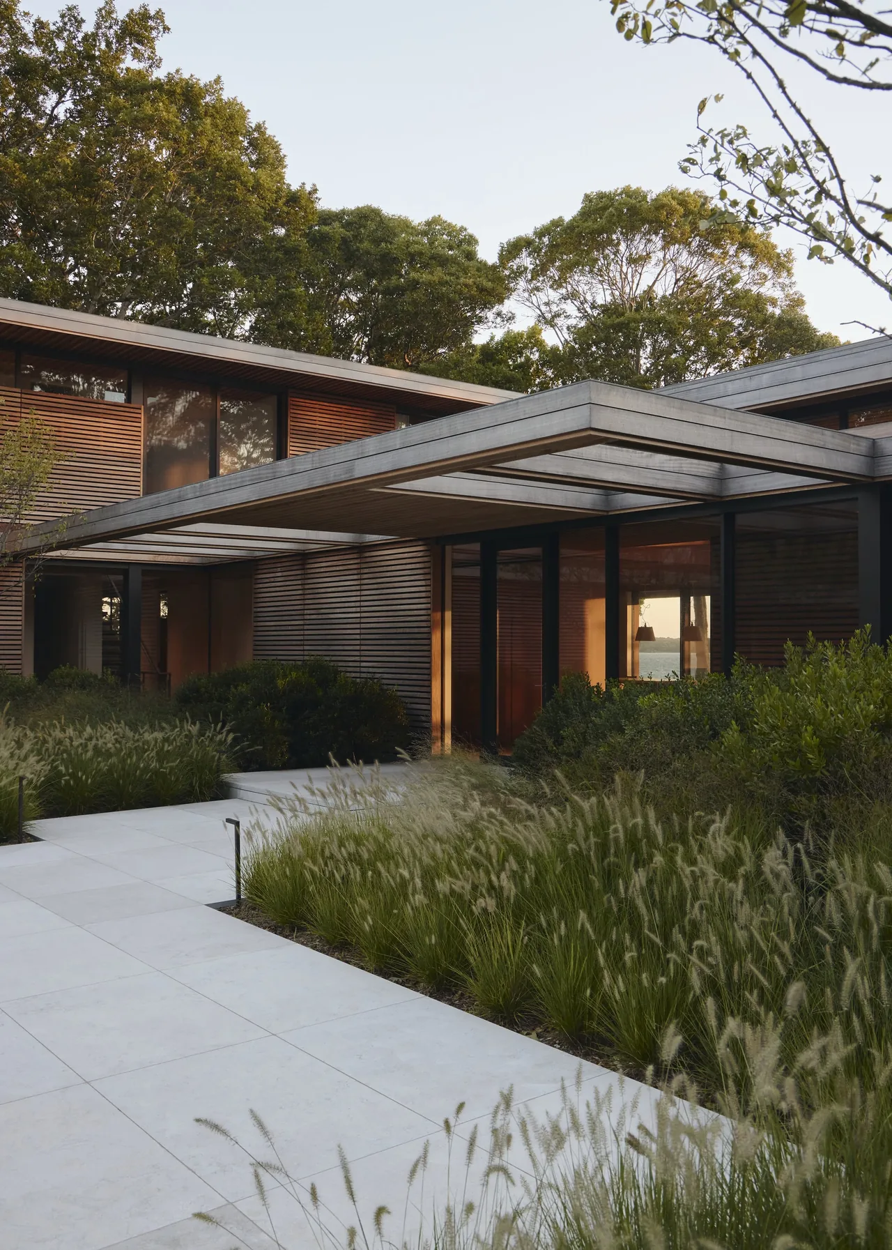 Modern house exterior featuring horizontal wood slats and large glass windows at the Forest Edge project.