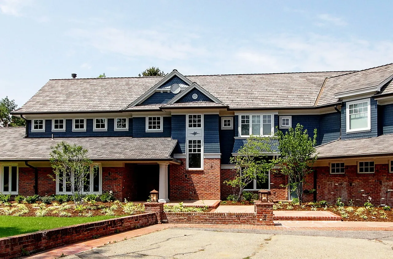 Transitional country-style remodel with blue wood siding and red brick exterior in Cherry Hills Village.