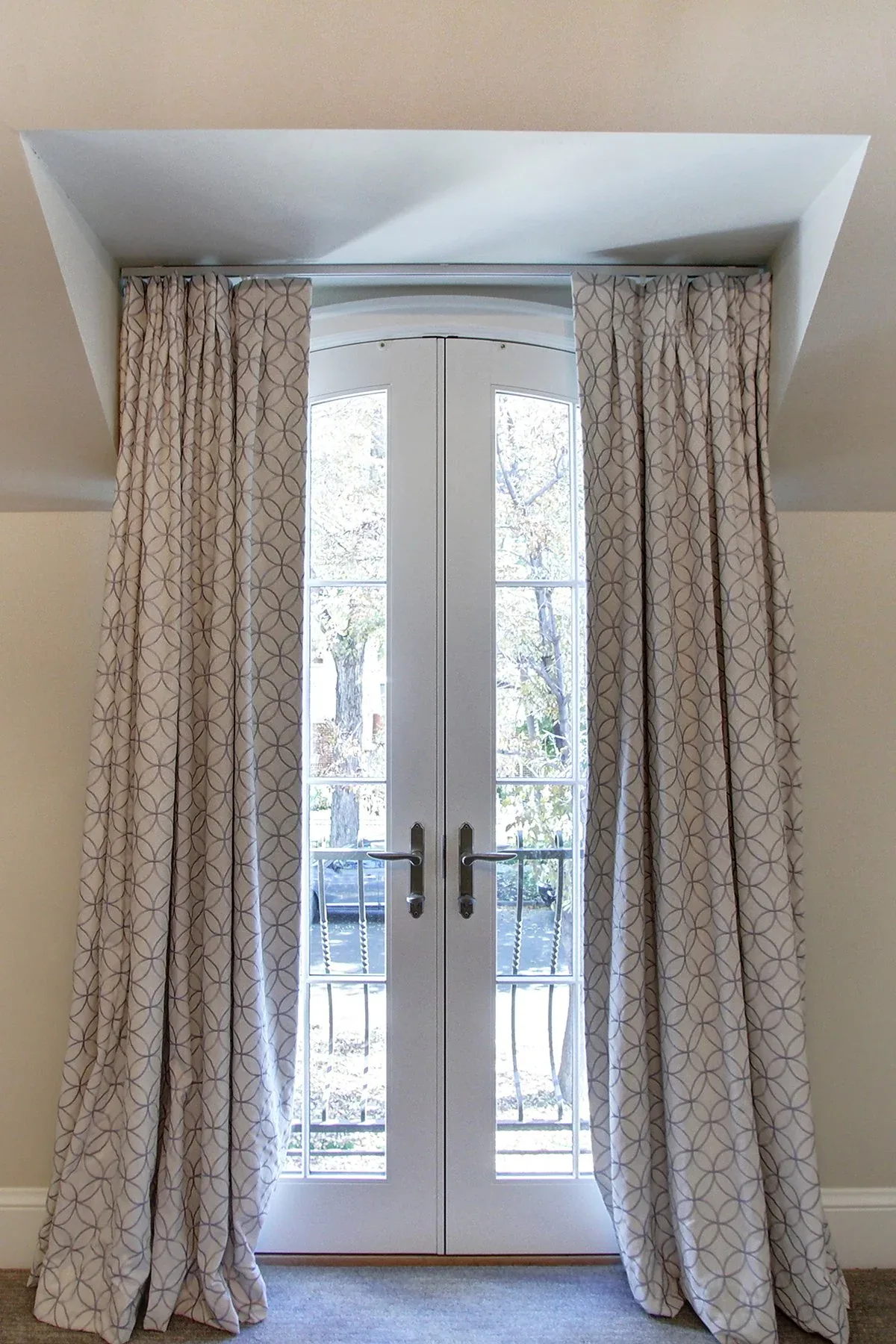 Interior view of French double doors with glass panes and patterned curtains in a Wash Park home.