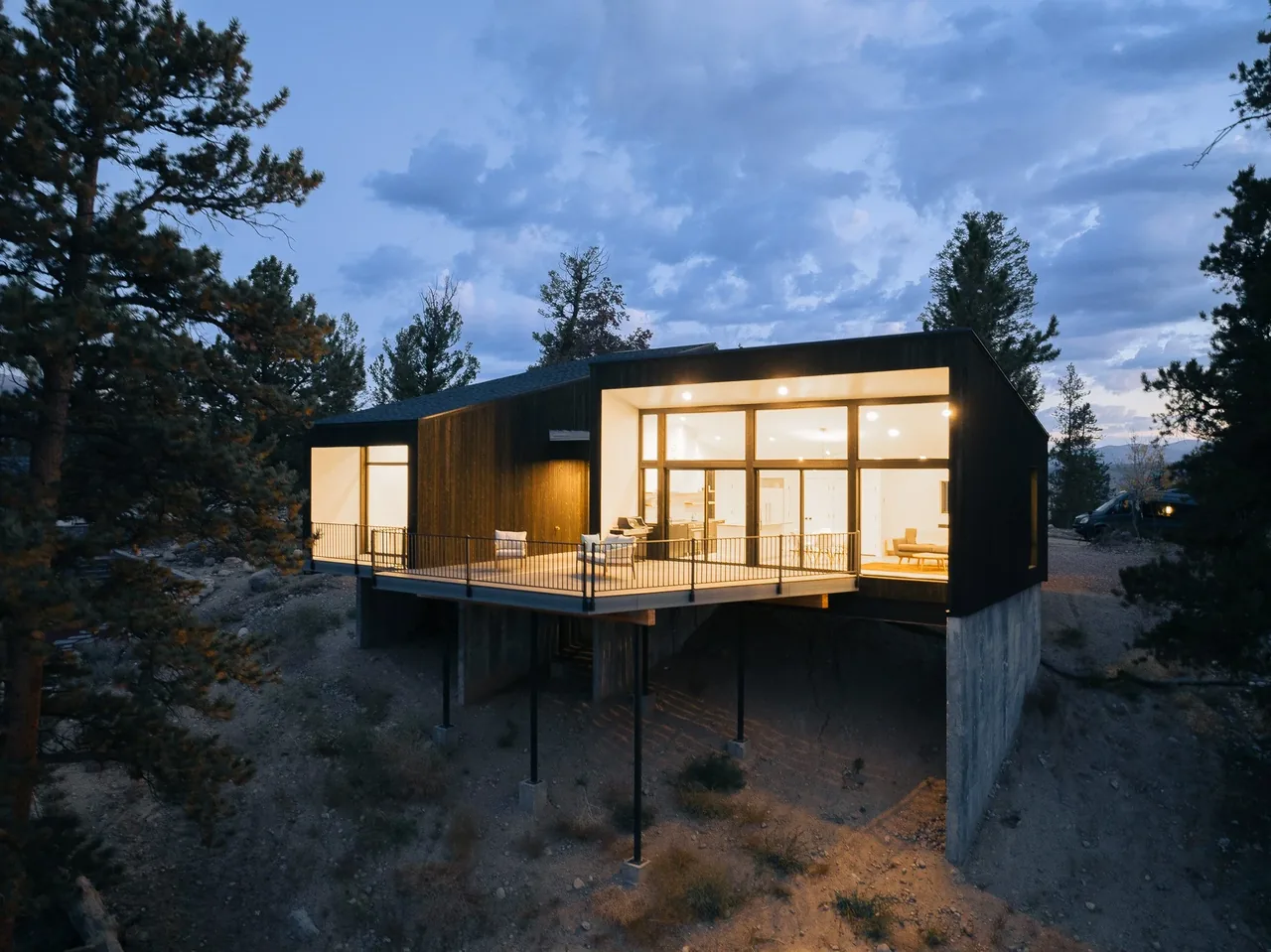 Twin Lakes Bothy features an elevated deck and extensive glazing for mountain views by Shape Architecture Studio.