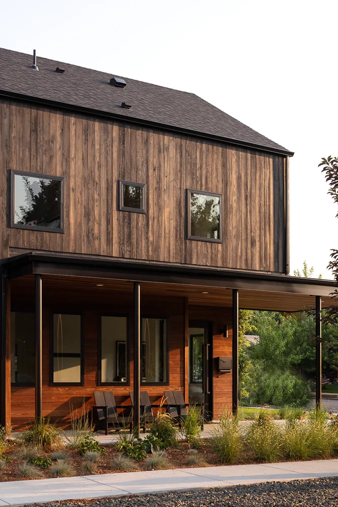 43rd Residence - C.S. House 1 features vertical wood siding and multiple small square windows with a covered front porch.