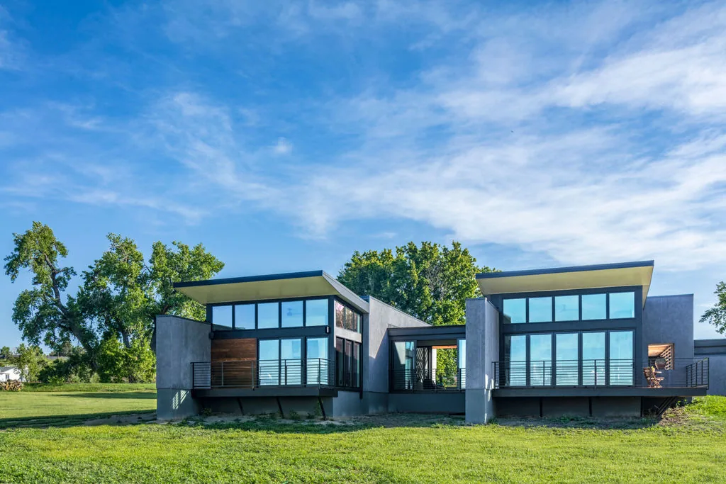 The Hoff Residence features large windows, metal railings, and cantilevered balconies with textured wall finishes.