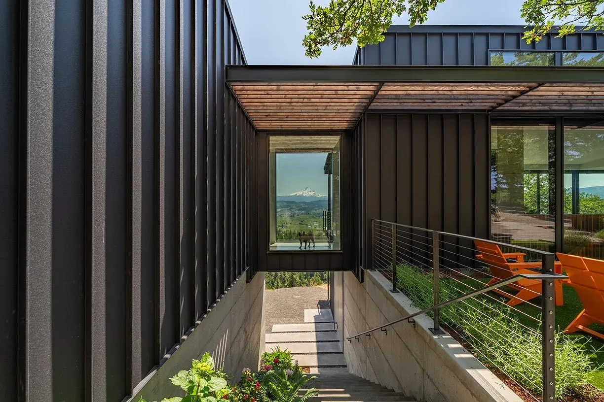 Hidden Oaks Residence exterior stair and outdoor seating area with black metal cladding and mountain view.
