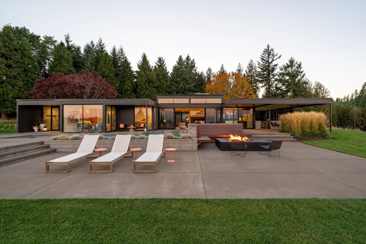 Burnt Tree Farm features a modern single-story house with a landscaped yard and outdoor fire table with seating.