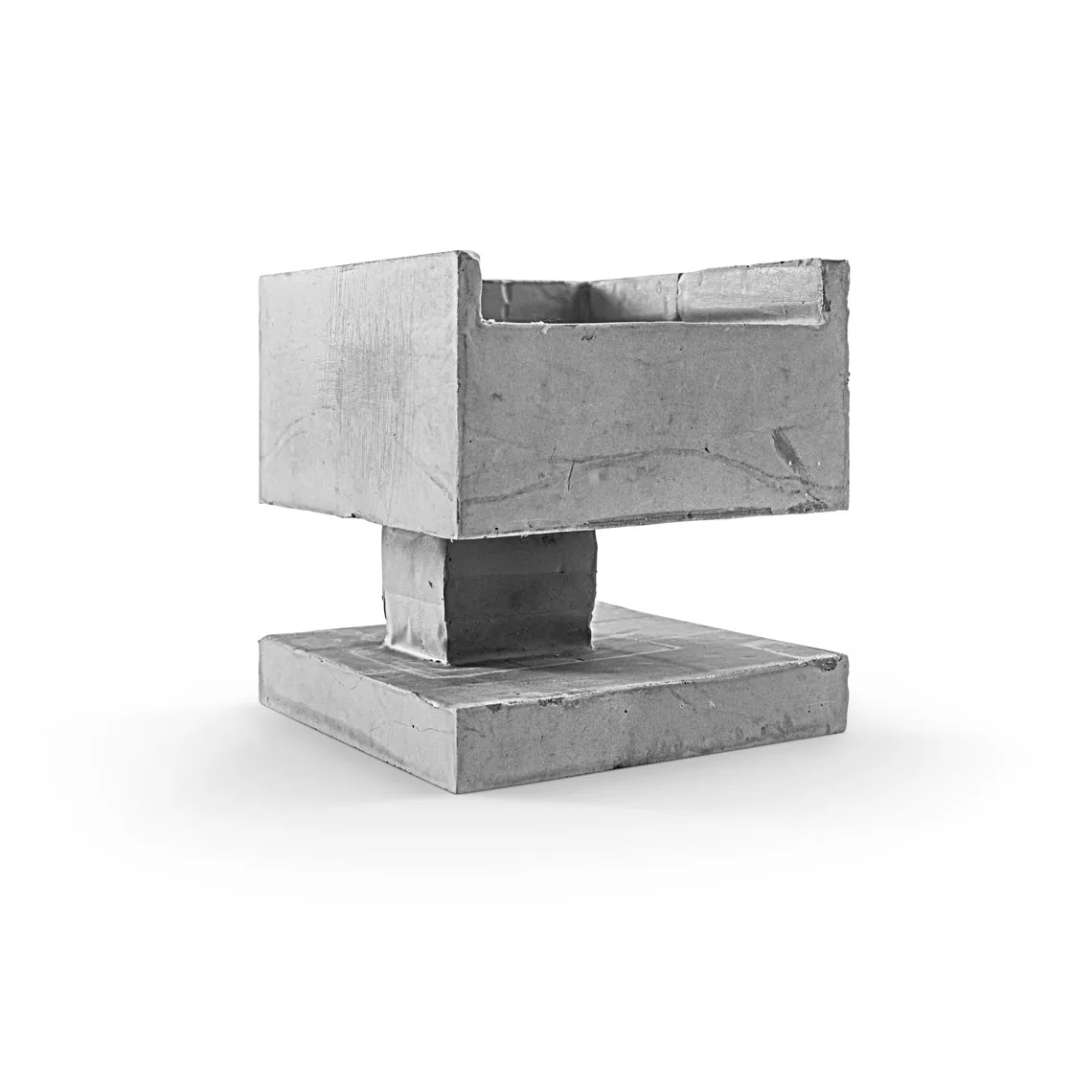 Cardboard model of a modern architectural design with a raised rectangular volume on a square base.
