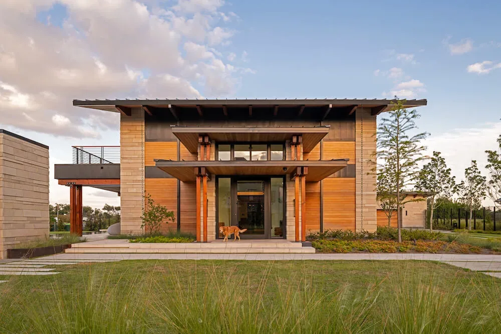 Pelican House front facade featuring wood and concrete materials with a flat roof and large glass entry by Winn Wittman Architecture.