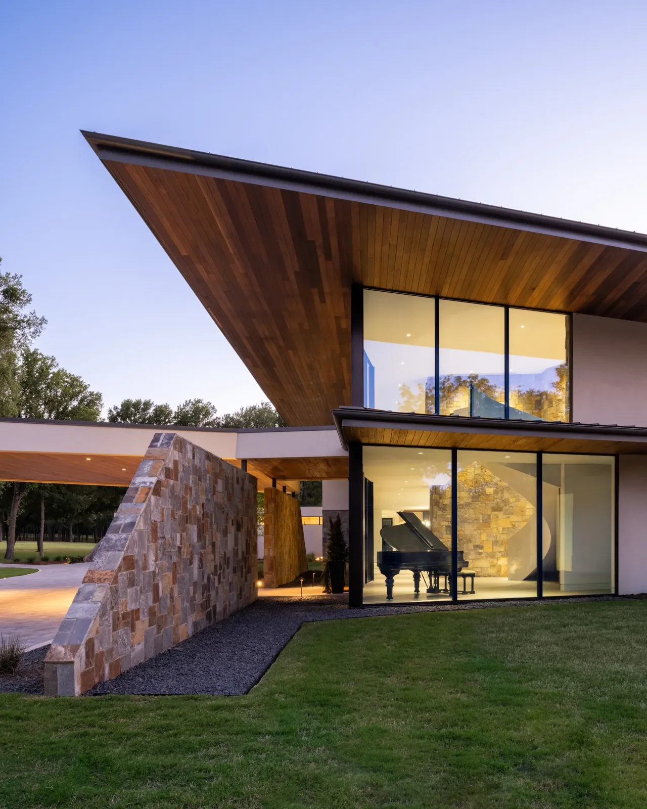 Horse Ranch features a modern exterior with large glass panels, a wood ceiling, and a stone wall near the entry.