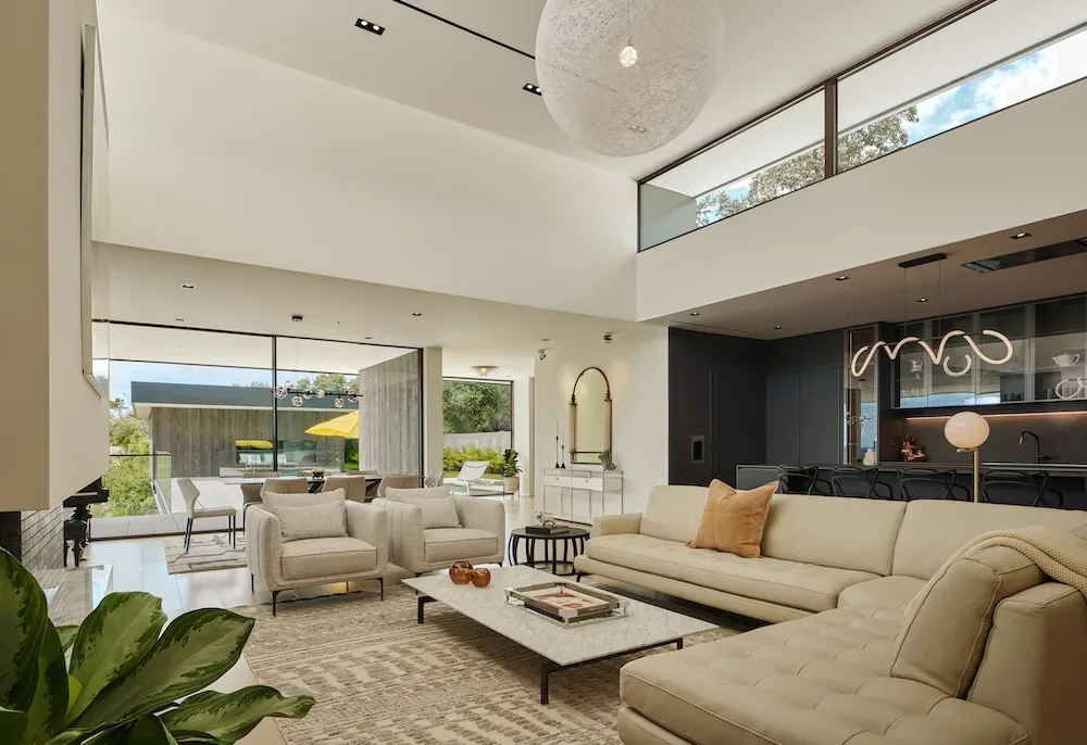 Modern living room in Villa Morada with large floor-to-ceiling windows and a vaulted ceiling with clerestory windows.