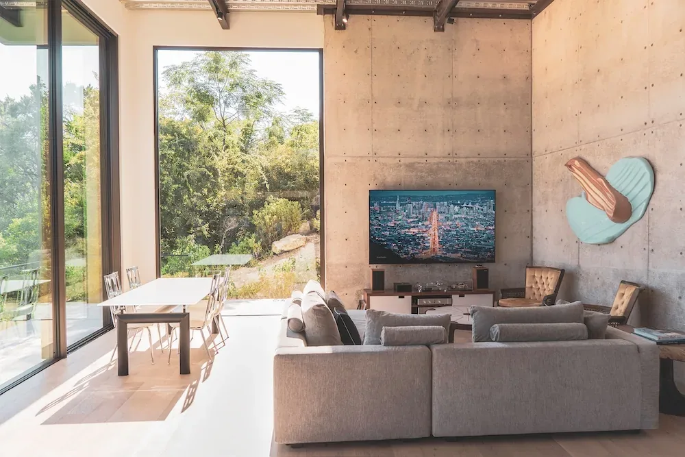 Villa Morada living space with concrete walls, large windows, and modern furnishings by Winn Wittman Architecture.