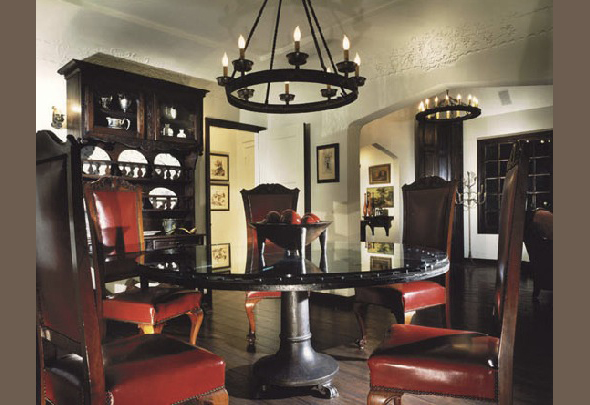 Dining room features a round dark wood table surrounded by red leather high-back chairs and matching dark wood cabinets and flooring.