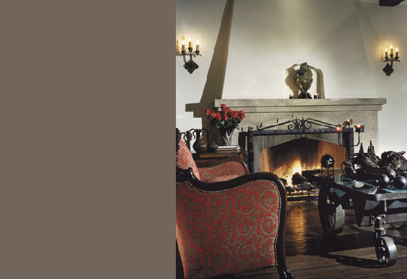 Living room featuring a stone fireplace with lit fire, antique furniture, and traditional wall sconces.