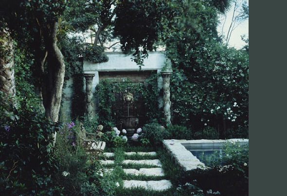 Garden entry with stone steps and lush planted surroundings near a stone-edged pool area at Alta Vista.