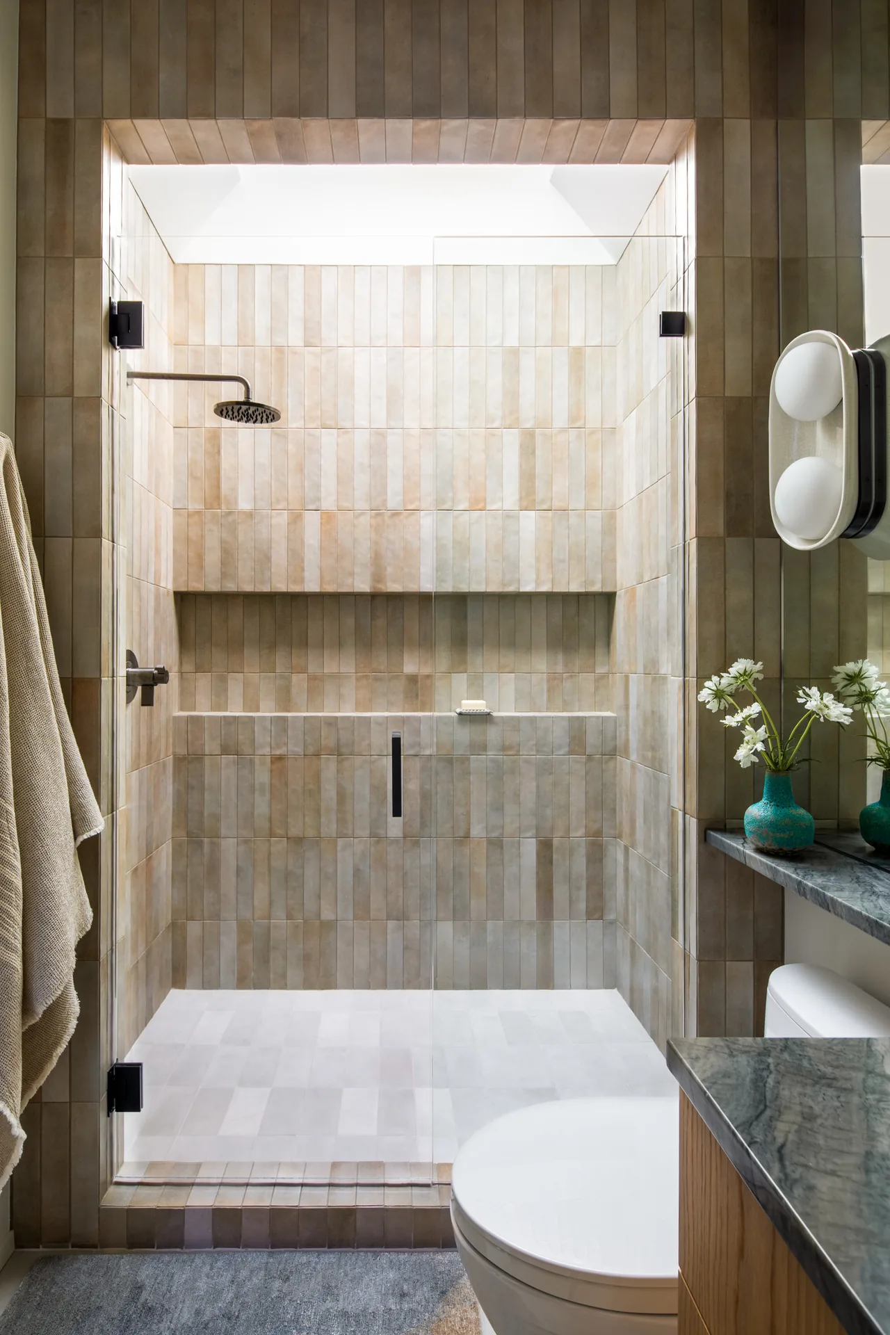 The Hillside House bathroom features a tiled walk-in shower with a rainfall showerhead and a skylight.