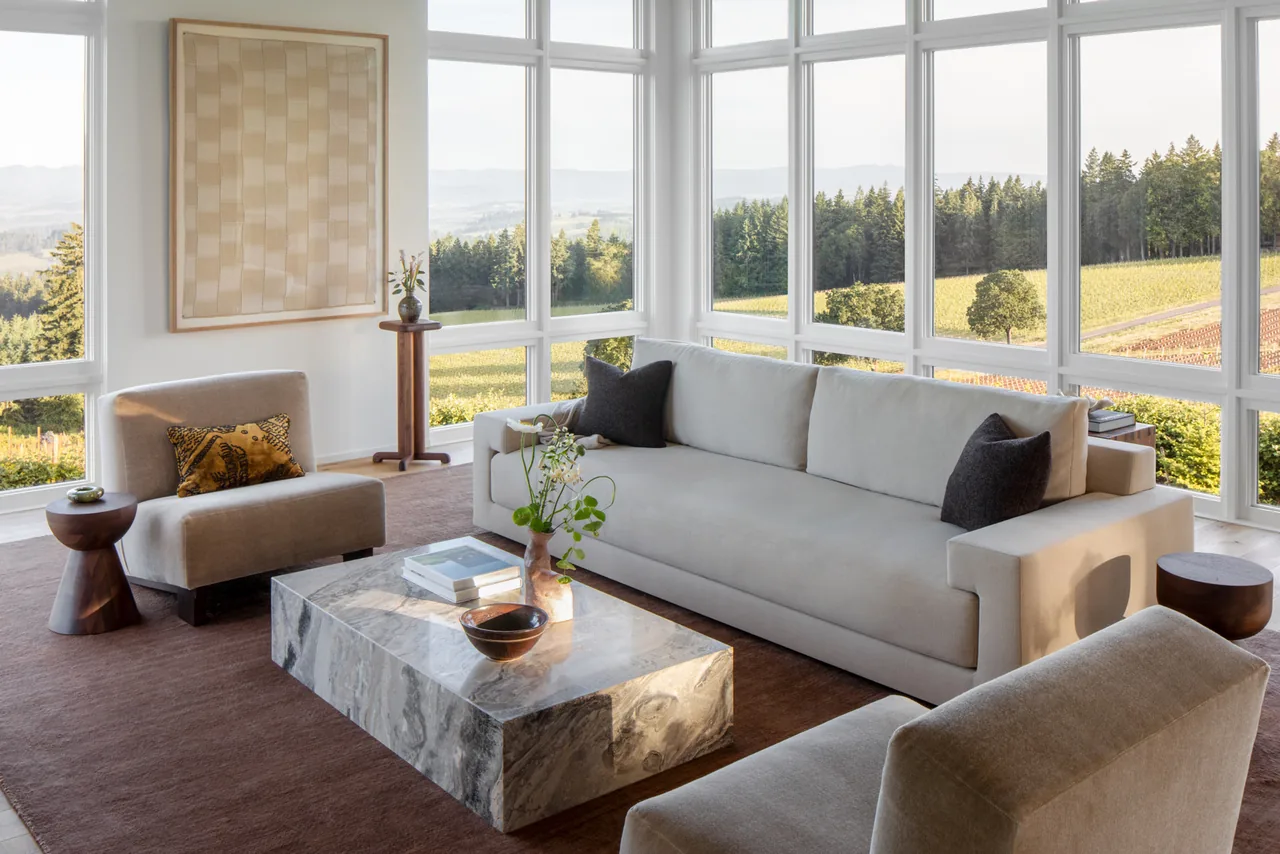 The Hillside House living room showcases floor-to-ceiling windows with expansive views of nature and farmland.
