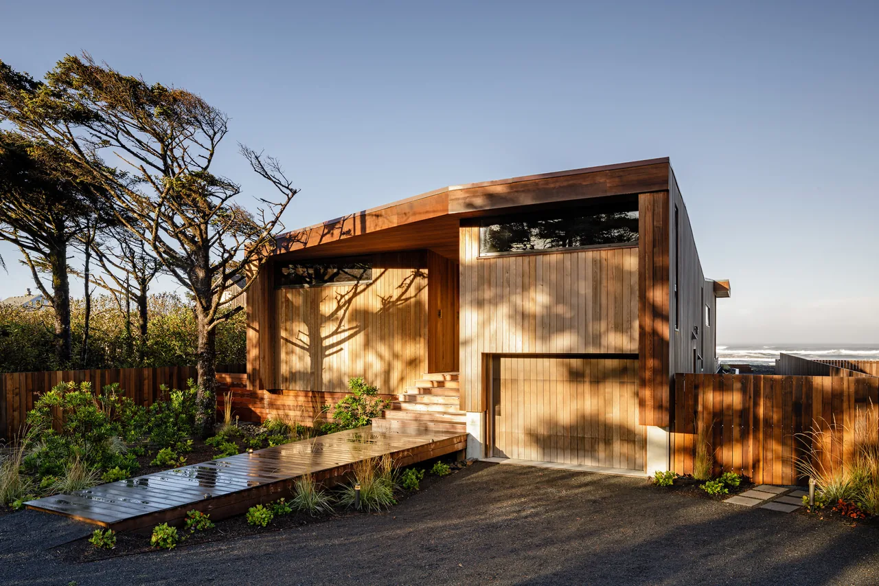 Wood-paneled exterior of Shelter House with a flat roof and narrow horizontal windows by JHL Design in Portland.