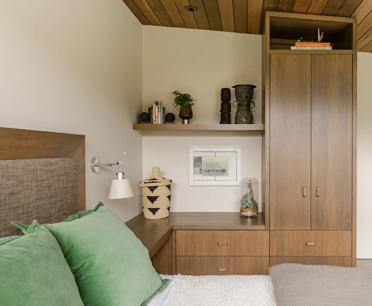 Bedroom corner with built-in walnut wood cabinetry and wood paneled ceiling.