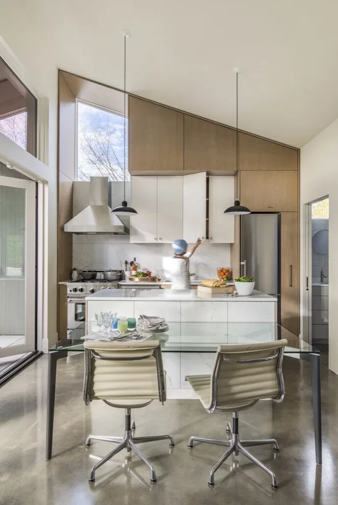 Kitchen with triangular clerestory window, white marble island, and pendant lighting in a mid-century inspired ADU.