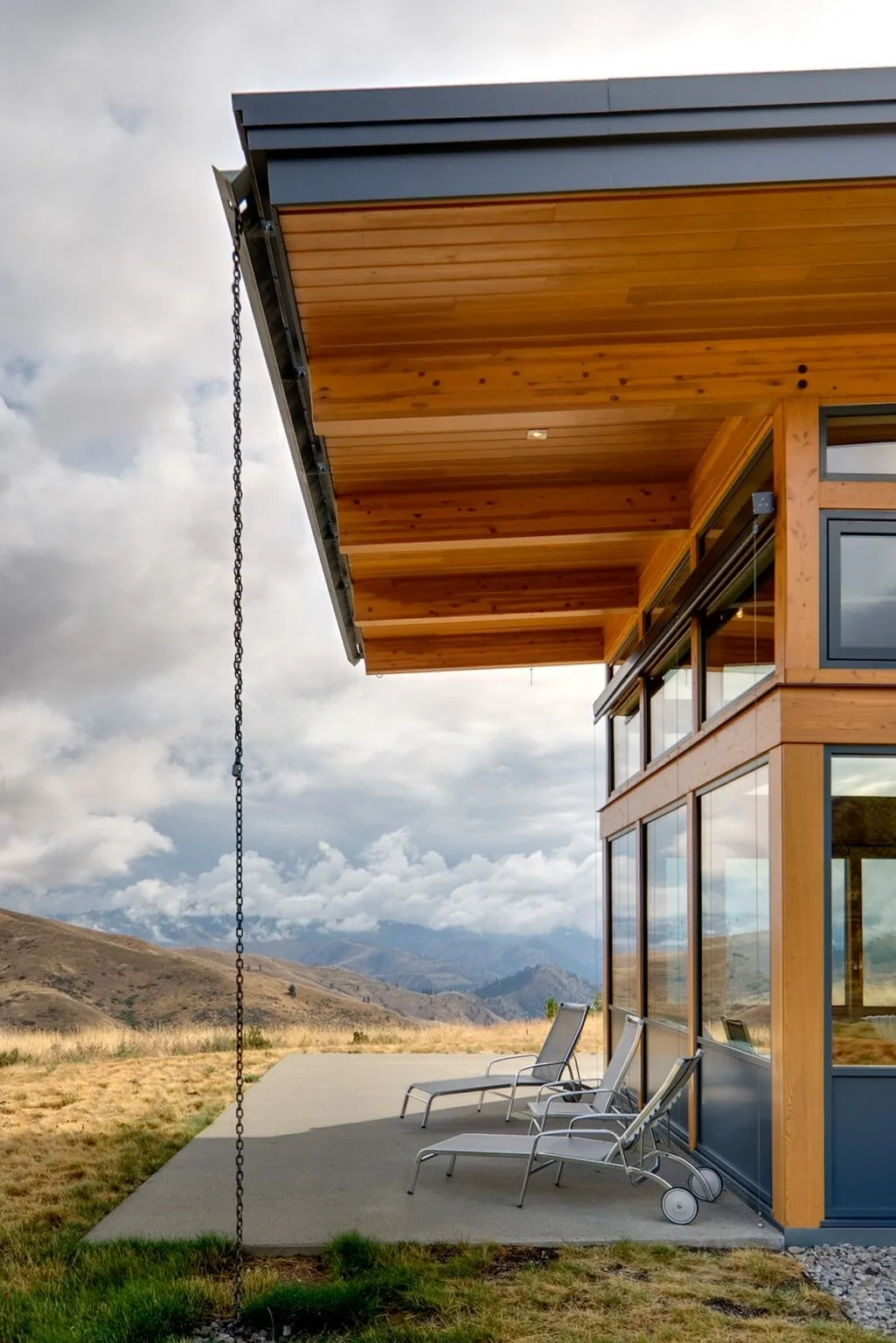 The patio features a wood ceiling with exposed beams under a large overhanging roof with corner windows.
