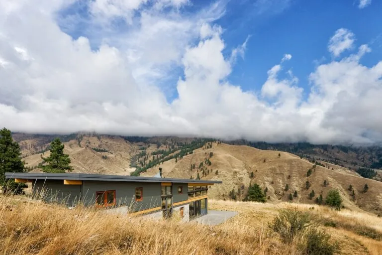 Nahahum Canyon Residence features a flat roof and panoramic windows with a view of the surrounding hills.