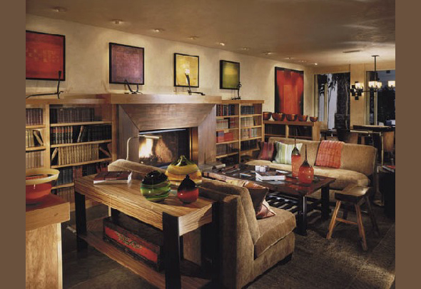Living room featuring built-in wood bookshelves, a fireplace, and multiple abstract paintings above the mantel.