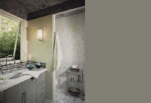 A modern bathroom features a marble countertop, textured stone flooring, and a walk-in shower with a glass shelving unit.