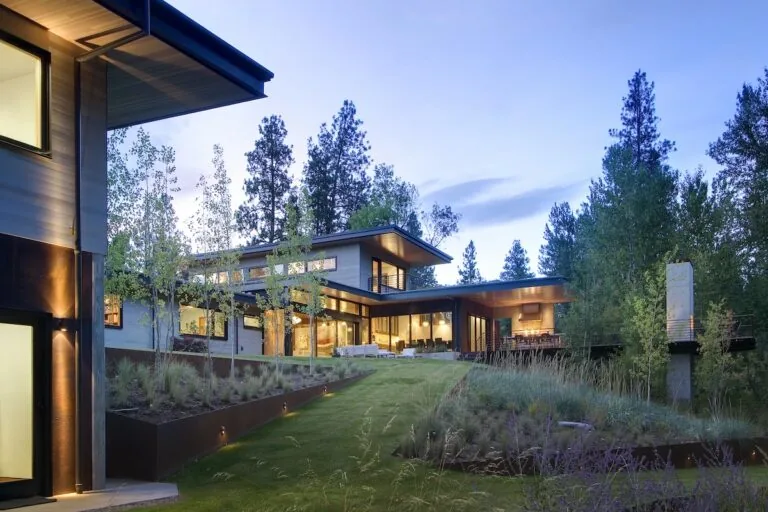 Montana Creekside Residence designed by Studio Zerbey, showing exterior with large windows and wood-paneled ceiling details.