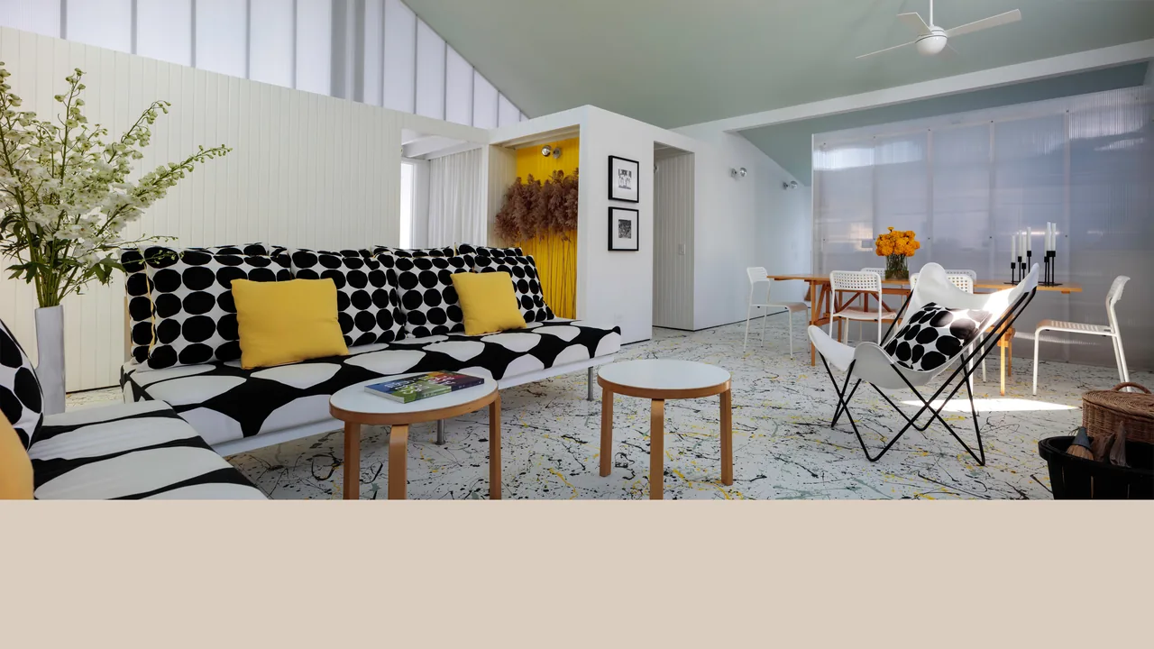 Living and dining space featuring polka dot upholstered sofas with yellow pillows and light wooden furniture in Spagnola House.