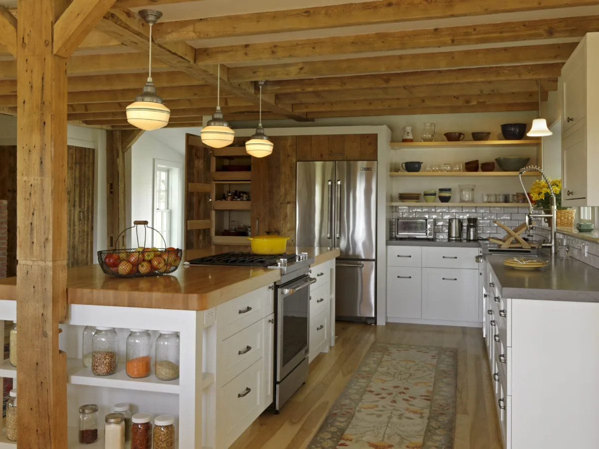 Kitchen featuring exposed wood beams, a stainless steel fridge, and white cabinets with open shelves.