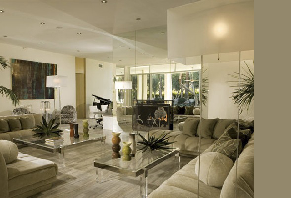 Living room featuring mirrored wall panels, beige sectional sofas, and a gas fireplace.