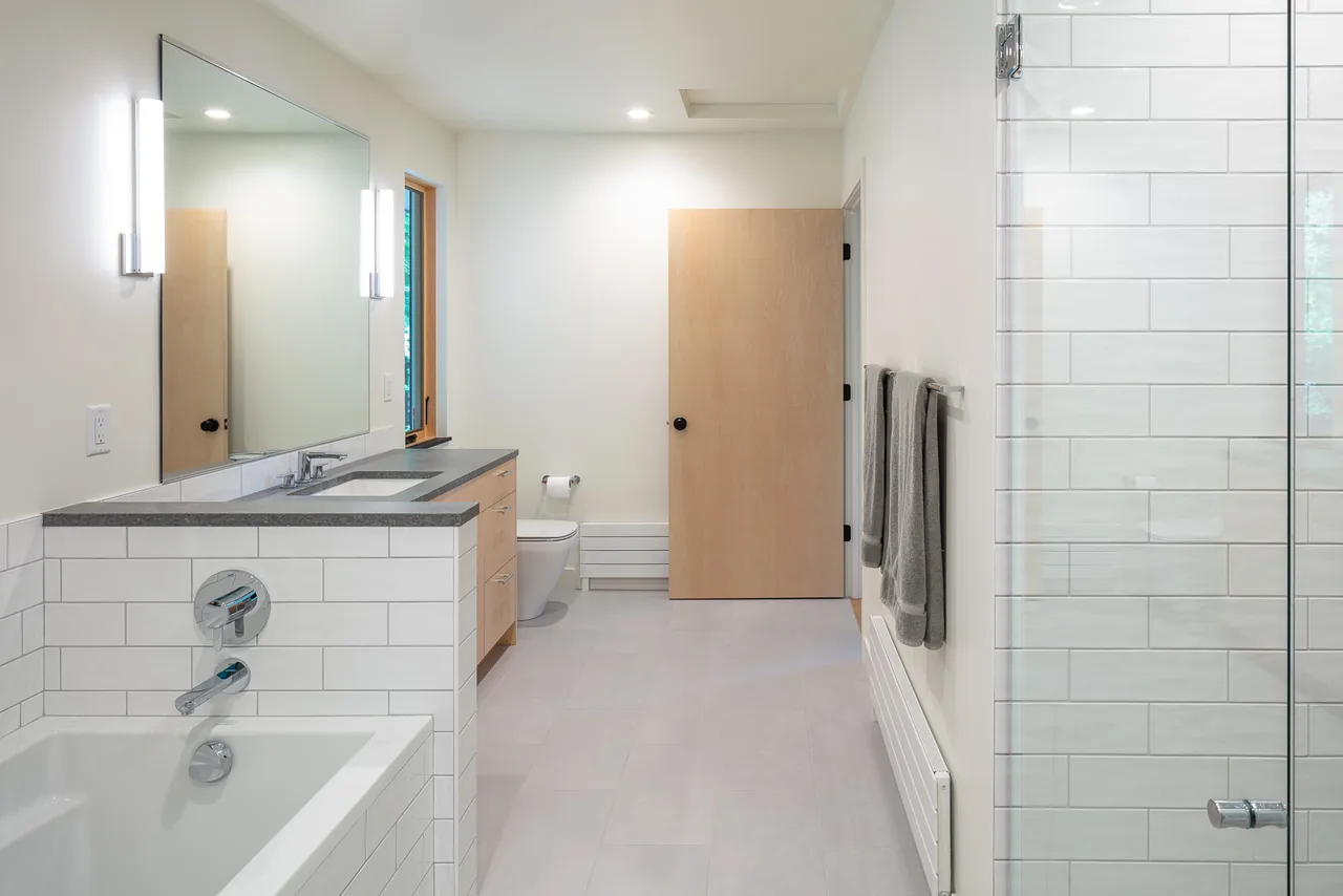 The River Residence bathroom features white subway tiles, a concrete countertop, and modern fixtures.