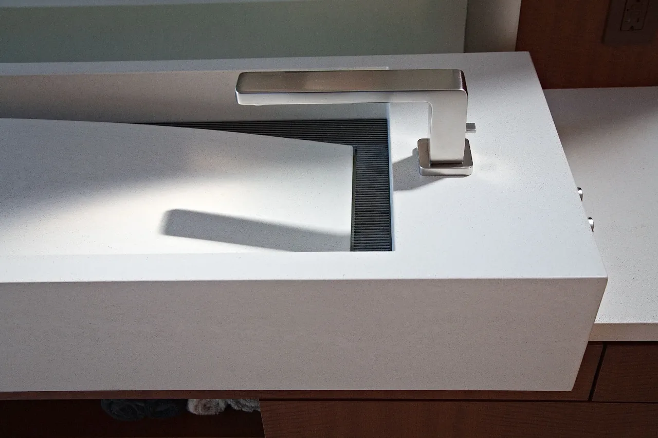Minimalist rectangular white bathroom sink with a modern metal faucet in Saratoga Creek House.