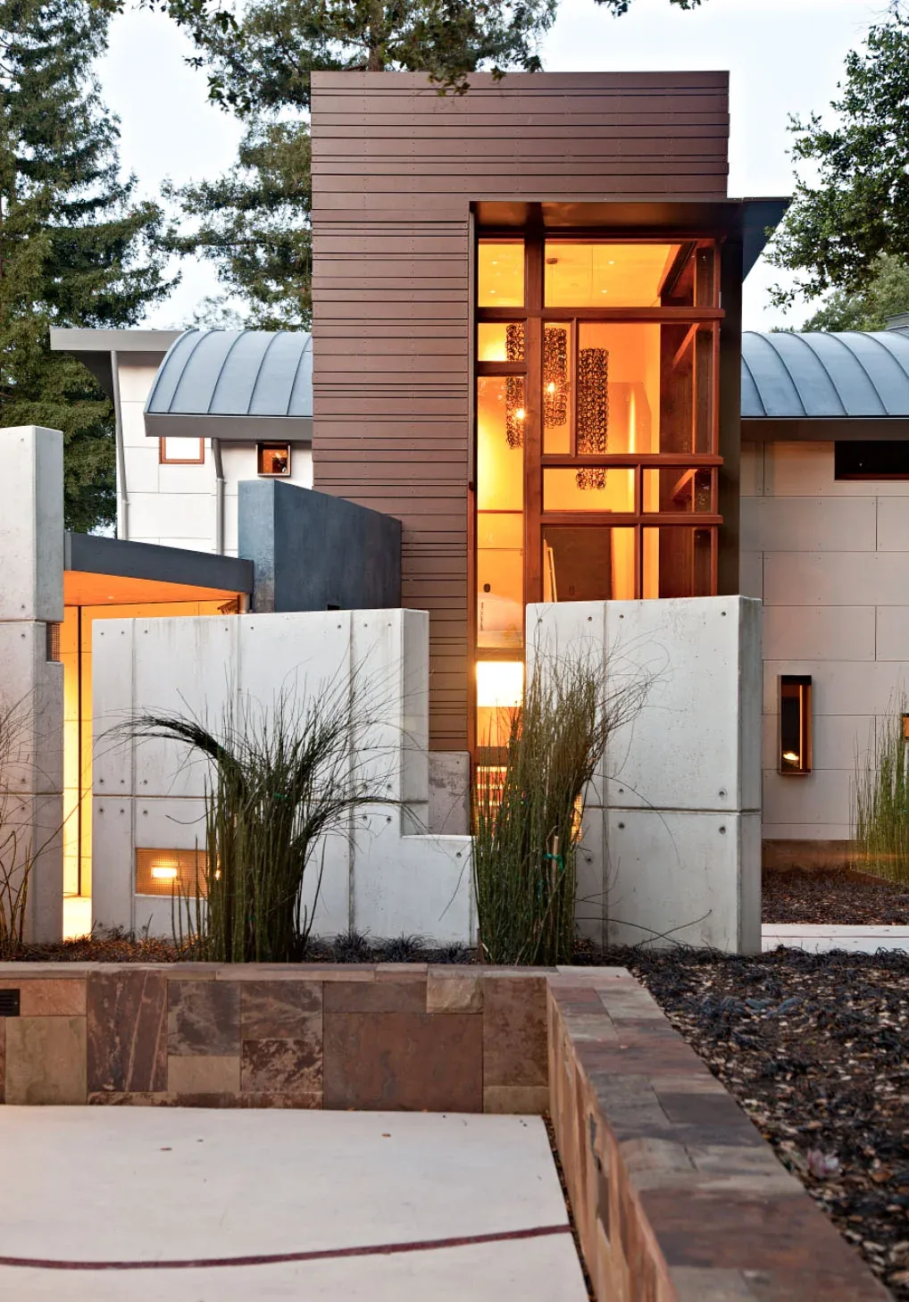 The Saratoga Creek House features a modern design with a distinctive tall window and mixed material facade.