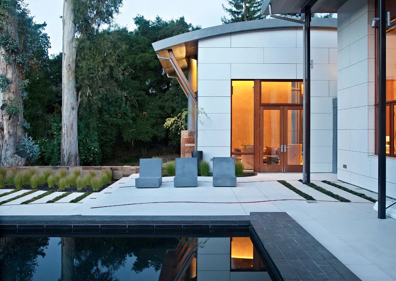 The Saratoga Creek House features a modern patio area with concrete seating and a reflecting pool.
