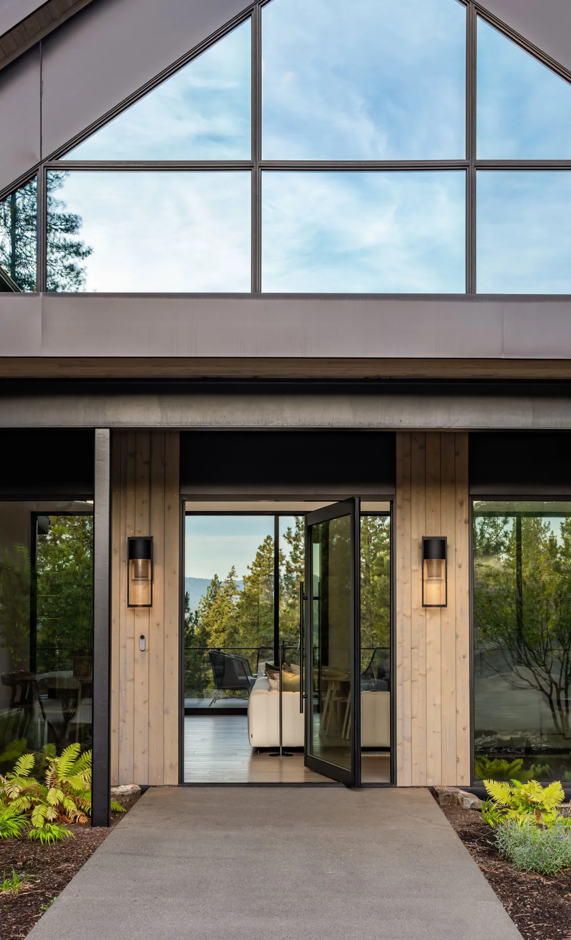 The Lakeside View project features a front entrance with a triangular window and black-framed glass pivot door.