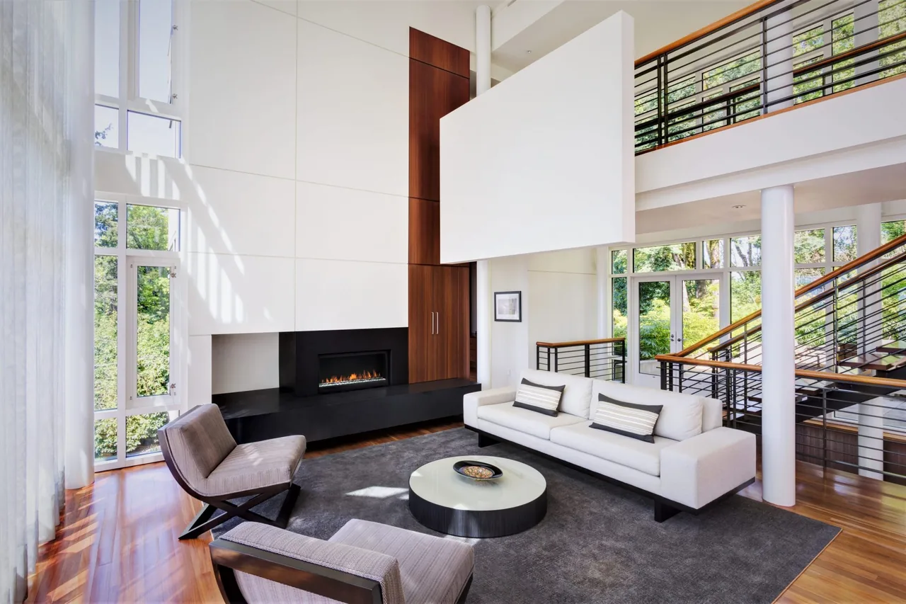 Living room in Hewett Street Residence featuring floor-to-ceiling windows, a linear fireplace, and a floating staircase with railing.
