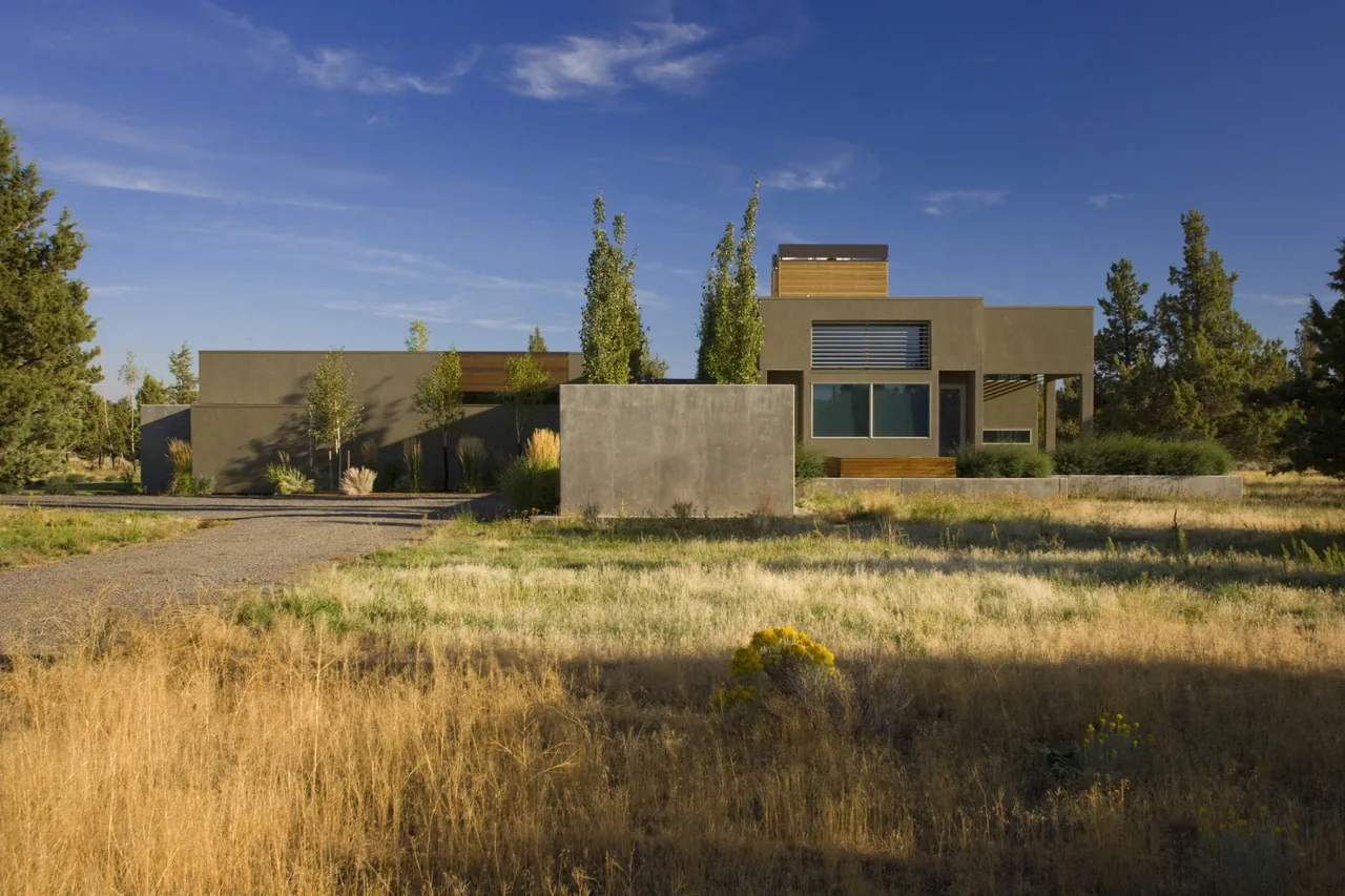 Fadjur Lane Residence by TVA Architects INC. features a single-story layout with horizontal sunshades and a dry grass landscape.