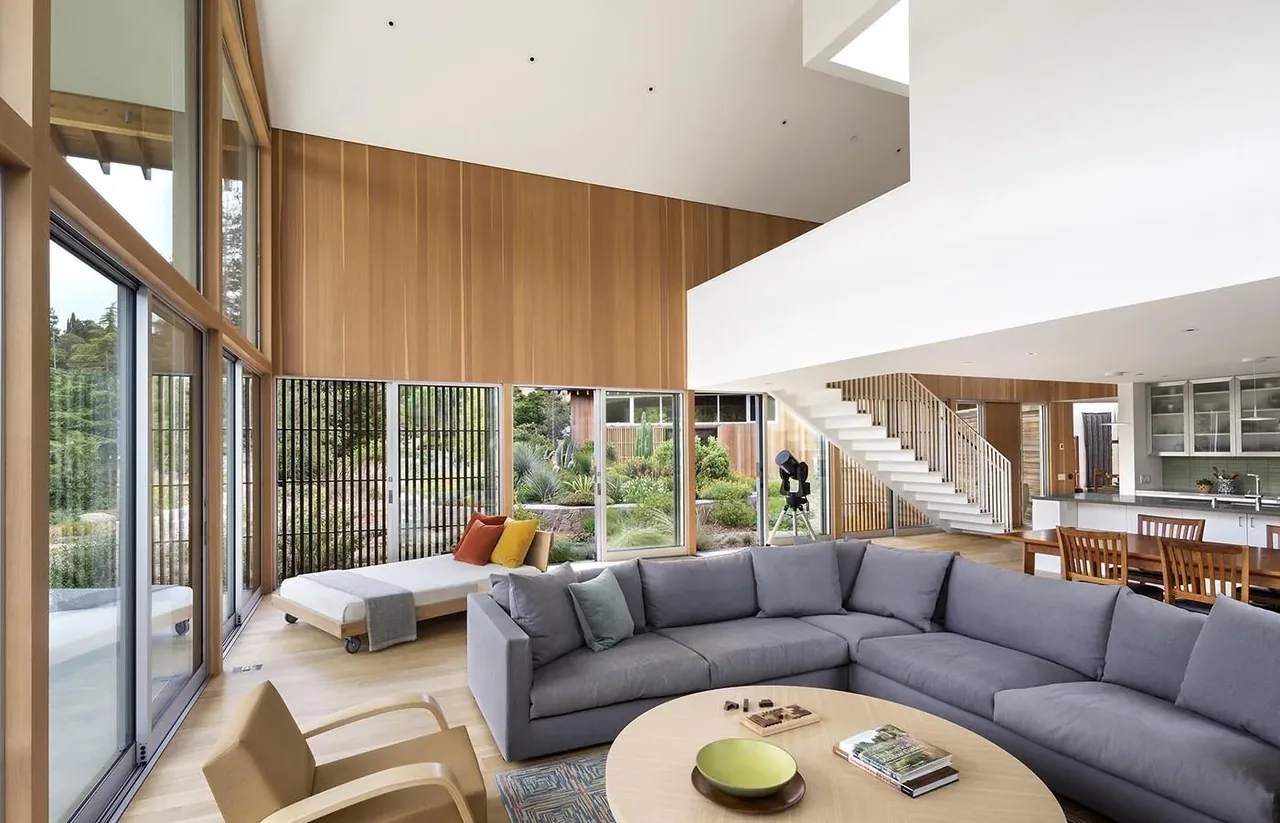 South Bay Residence living room with floor-to-ceiling glazing, vaulted ceilings, and wood panel accent wall by Turnbull Griffin Haesloop.