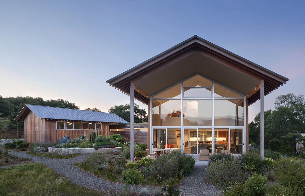 South Bay Residence features a modern design with expansive glazing and natural wood siding under a gable roof.