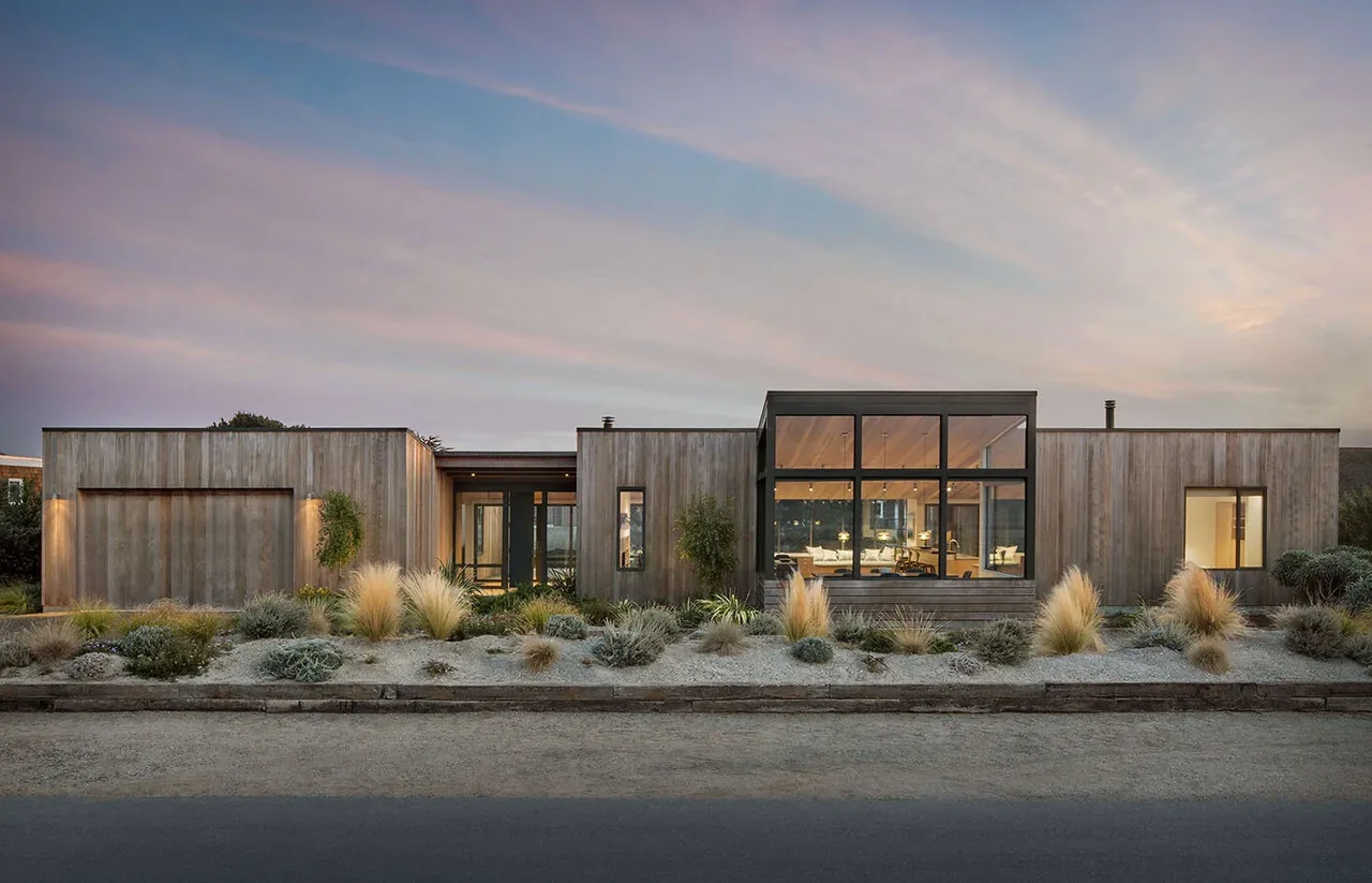 The Stinson Beach Lagoon house by Turnbull Griffin Haesloop features modern design with expansive black-framed windows and wood siding.