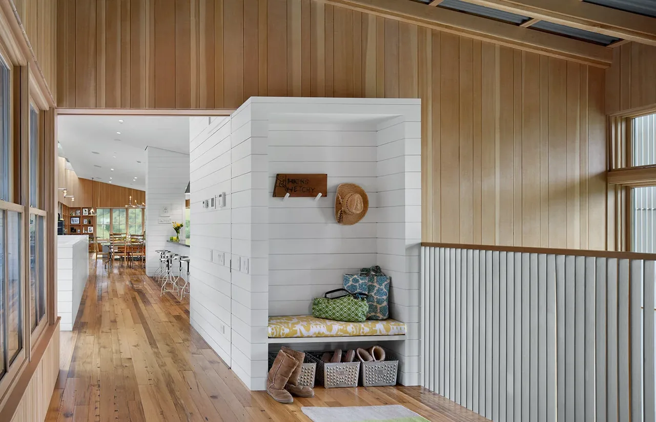 Hallway with wood-paneled walls and a built-in cushioned window seat with storage underneath.