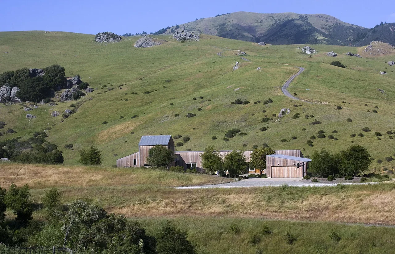 West Marin Ranch by Turnbull Griffin Haesloop sits amid grassy hills with natural landscaping.